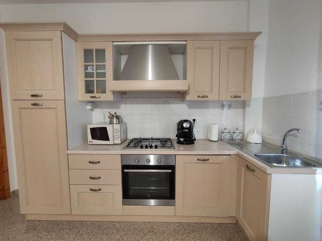 uma cozinha com um lavatório e um fogão forno superior em Apartment Stella Maris em Cala Gonone