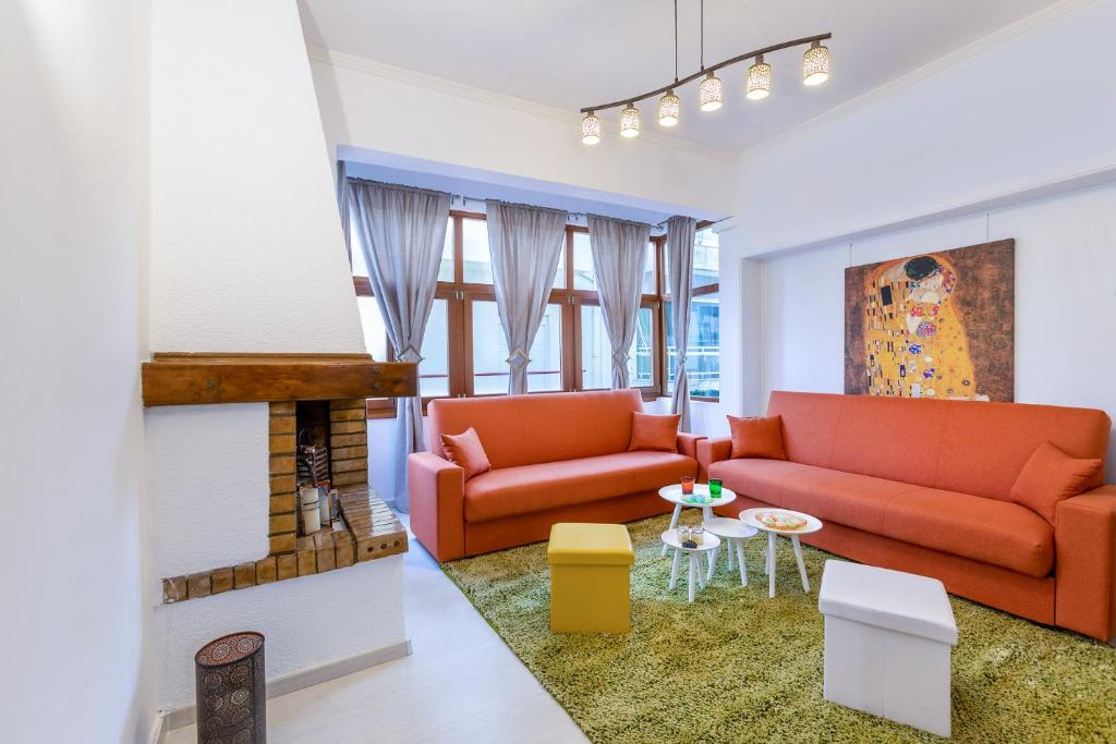 un salon avec deux canapés orange et une cheminée dans l'établissement Minotavros Cozy Apartment in Heraklion, à Héraklion