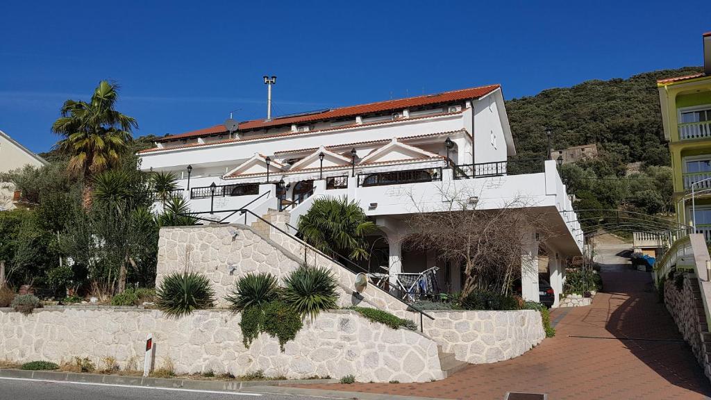 a white building with a staircase in front of it at Guest House Galeb in Supetarska Draga