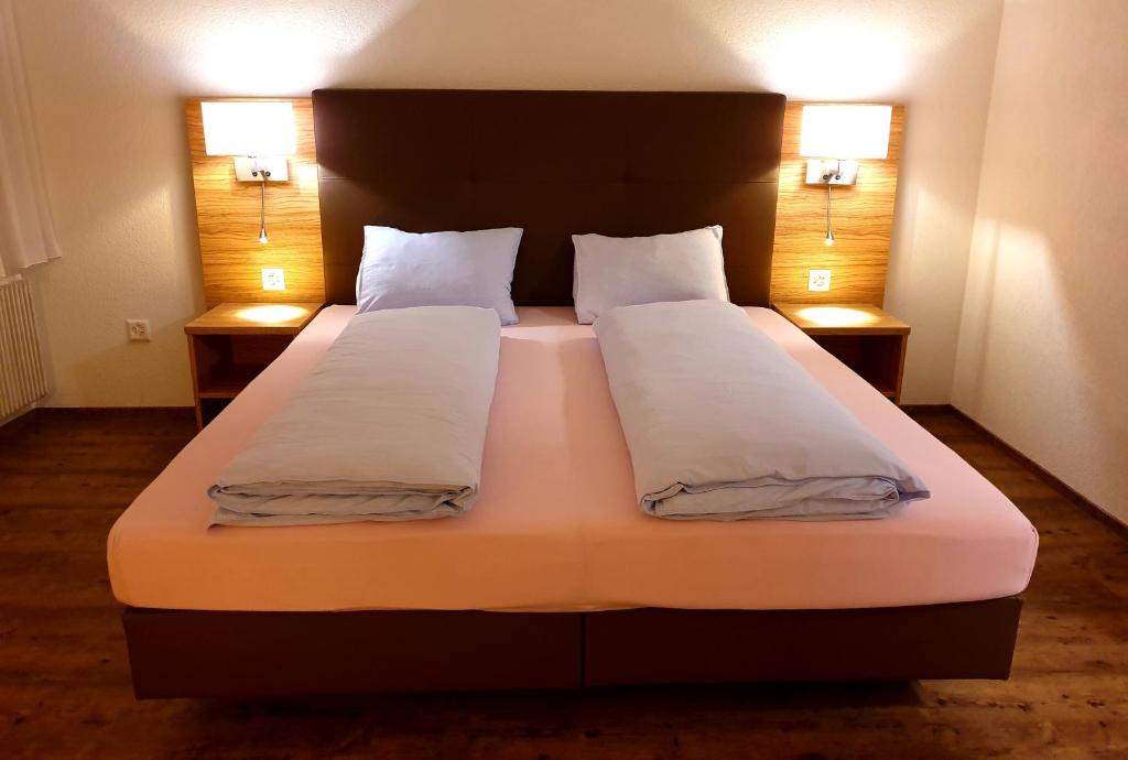 a bedroom with a large bed with two pillows at Hotel Römerbad in Zofingen