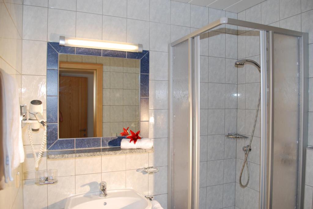 a bathroom with a shower and a sink and a mirror at Chasa Monthani in Ischgl