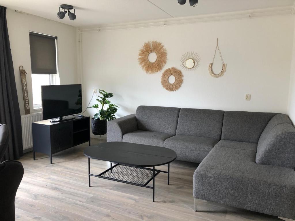een woonkamer met een bank en een tafel bij Puur Texels 12 in De Koog