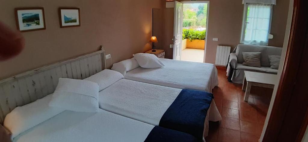Parres de LlanesにあるLa Quintana del Cueraのベッド2台とソファが備わるホテルルームです。