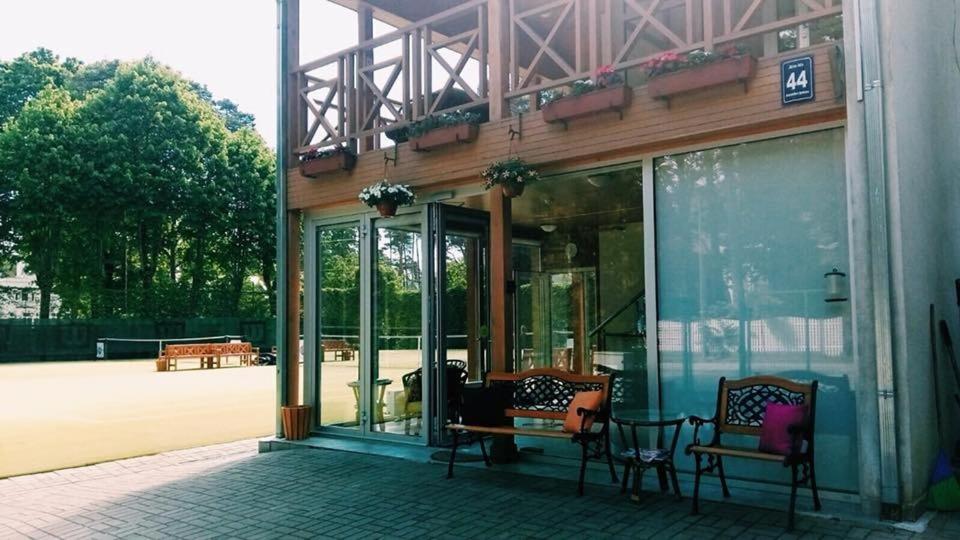 a building with two chairs sitting outside of it at Tenisa klubs Jūra in Jūrmala