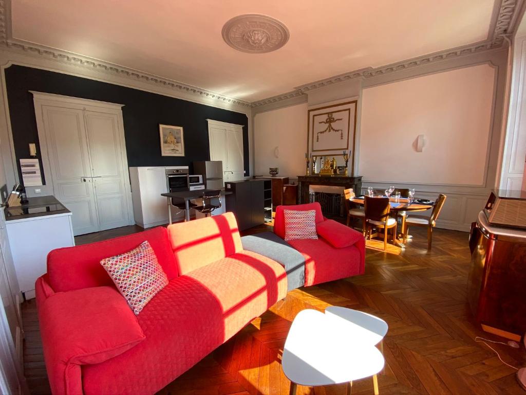 uma sala de estar com um sofá vermelho e uma mesa em Lysbed - Chevreul em Angers