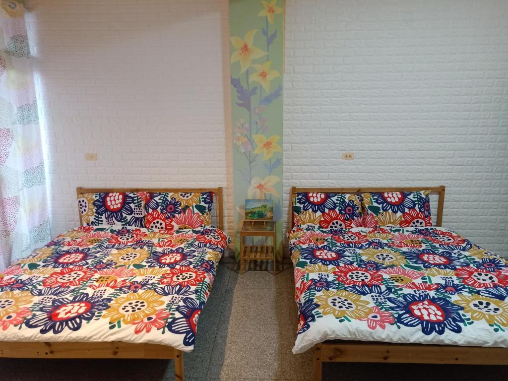 two beds sitting next to each other in a room at Fish Hostel in Yingge