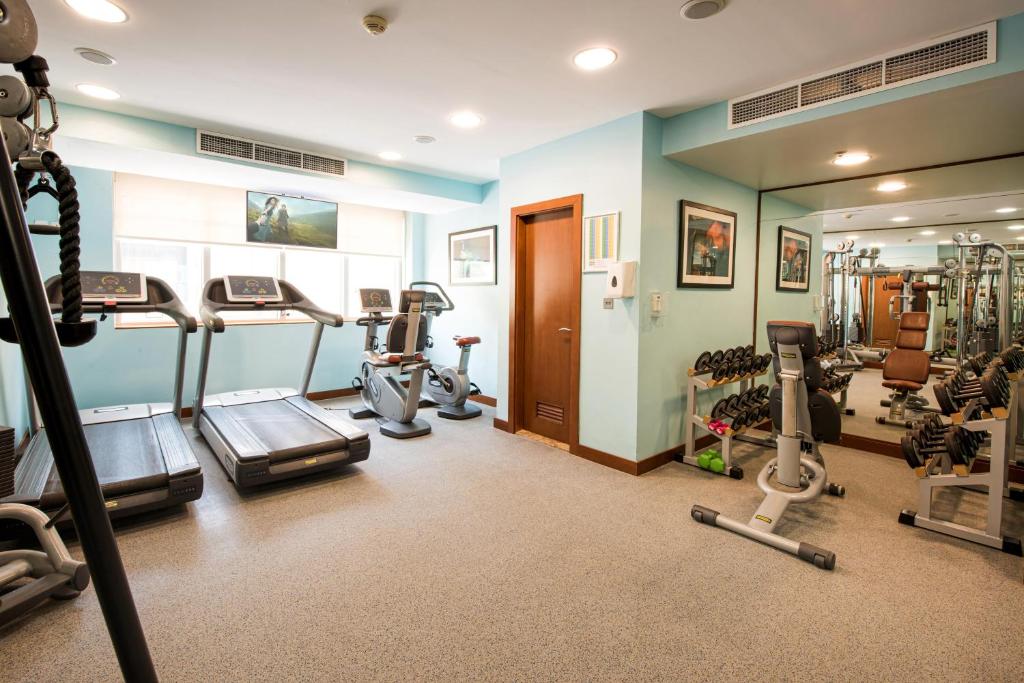 a gym with several exercise equipment in a room at Al Rawda Arjaan by Rotana, Abu Dhabi in Abu Dhabi