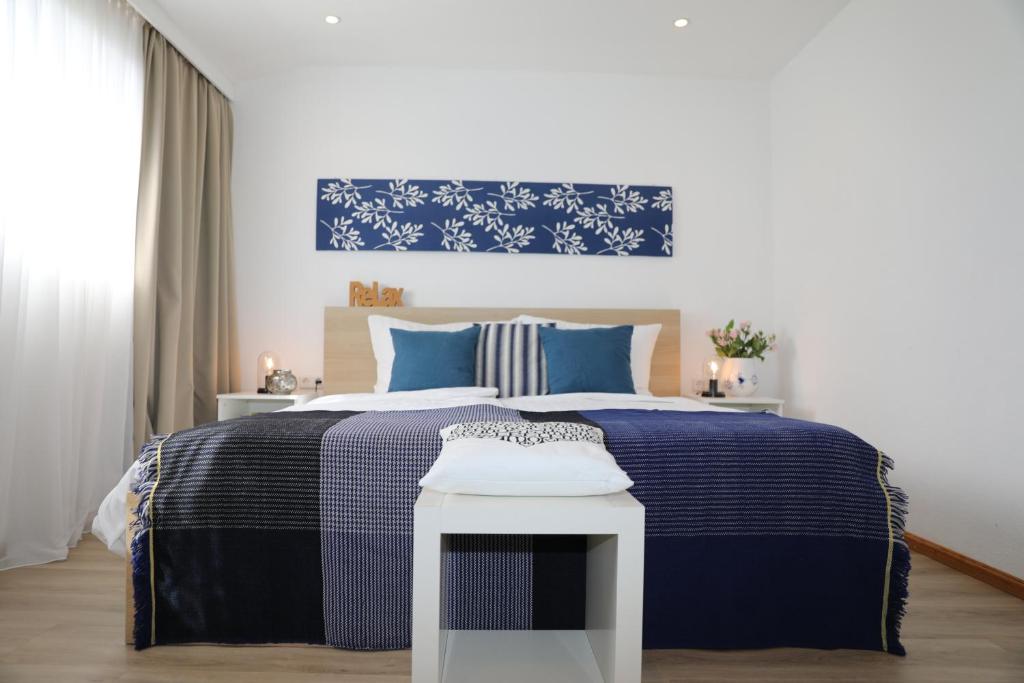 a bedroom with a blue and white bed and a table at Hotel Weinlaube in Koblenz