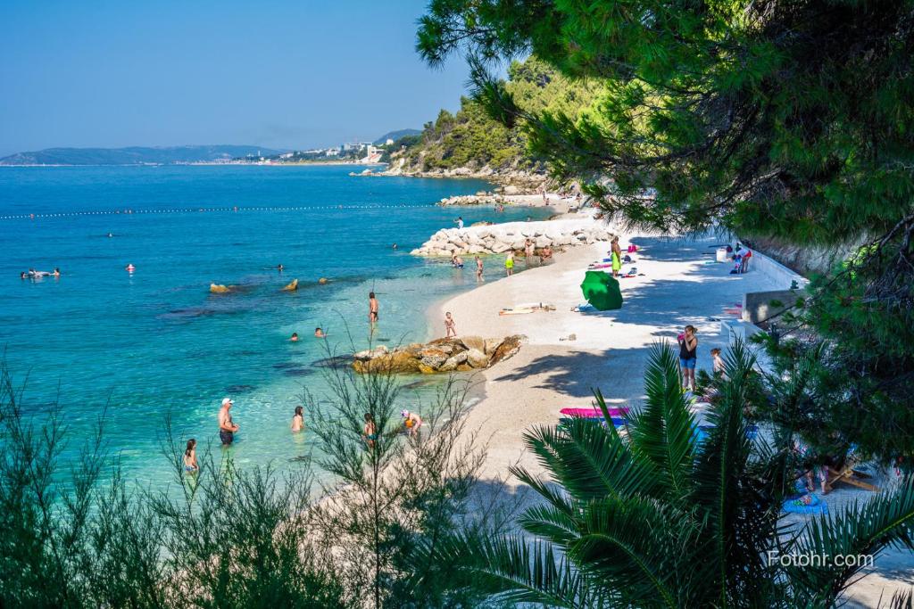 una playa con un montón de gente en el agua en Apartmani Mary, en Split