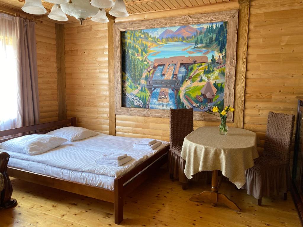 シネヴィルにあるZatishna Khataのベッドルーム1室(ベッド1台、絵画のあるテーブル付)