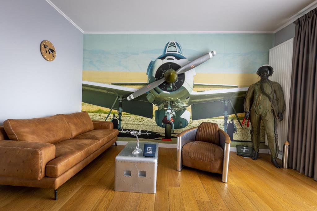 a living room with a plane on the wall at The Aviator Apartment - Jacuzzi & Panoramic View in Cluj-Napoca