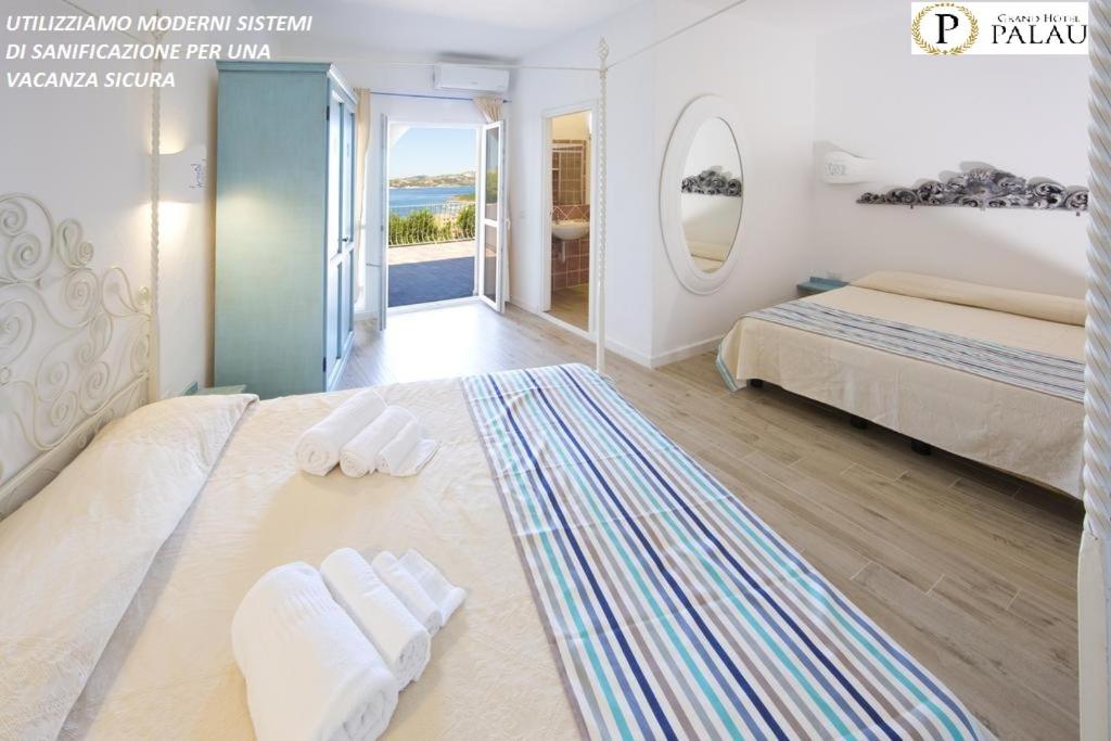 1 dormitorio con 1 cama con 2 toallas en Grand Hotel Palau en Palau