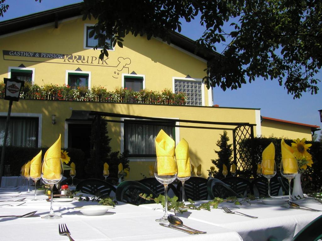 uma mesa com guardanapos amarelos e copos de vinho em frente a um edifício em Gasthof Pension Renate Krupik em Steinbach