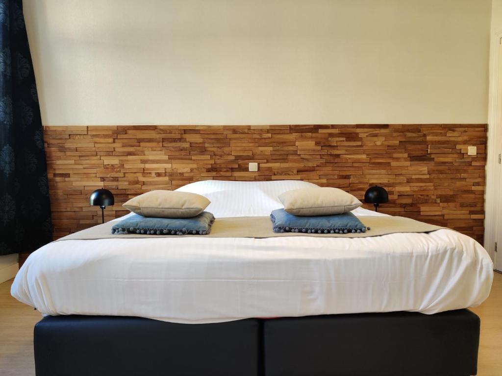 duże białe łóżko z 2 poduszkami w obiekcie Gastenverblijf De Arend w mieście Nieuwpoort