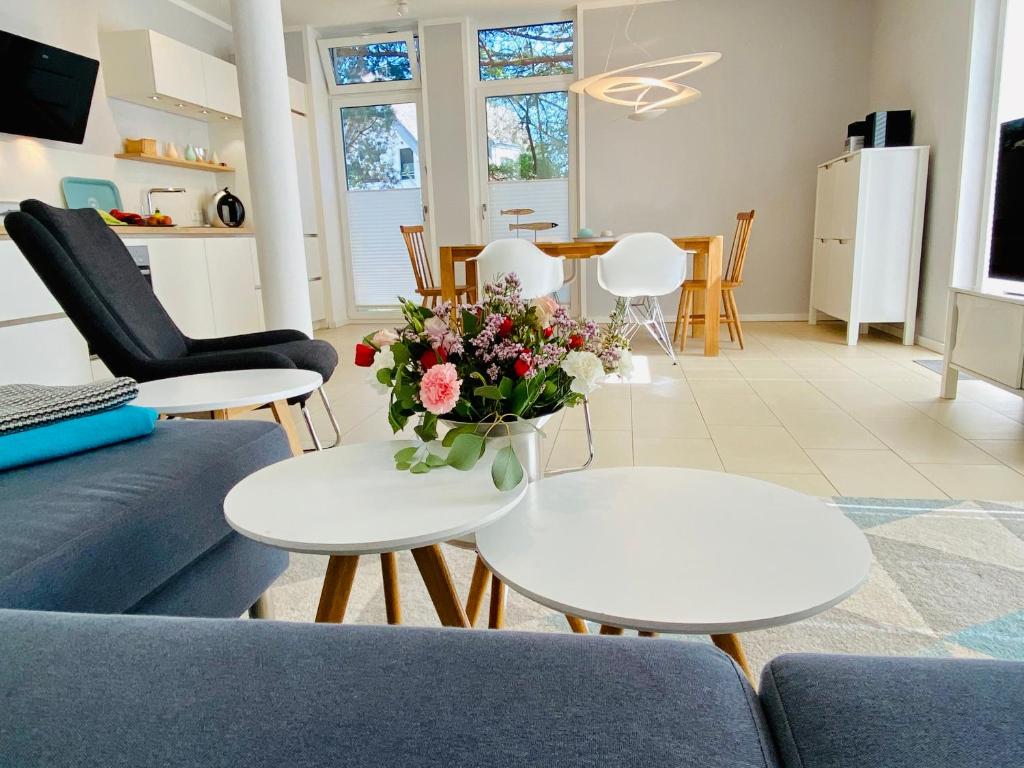 een woonkamer met een vaas met bloemen op een tafel bij Ferienwohnung Koje 2 in Ostseebad Karlshagen