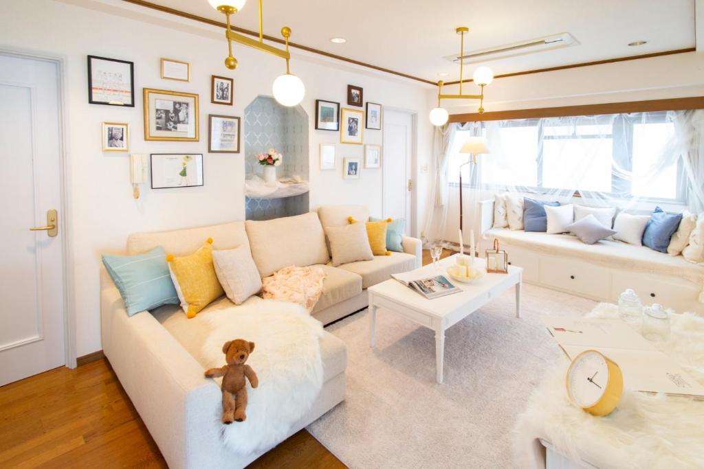 una sala de estar con un osito de peluche sentado en un sofá en HARMONIA東京堀切 10名定員90平米の広いCondominium en Tokio