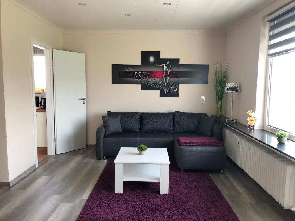 ein Wohnzimmer mit einem Sofa und einem Tisch in der Unterkunft Ferienwohnung Aueblick Kassel in Kassel