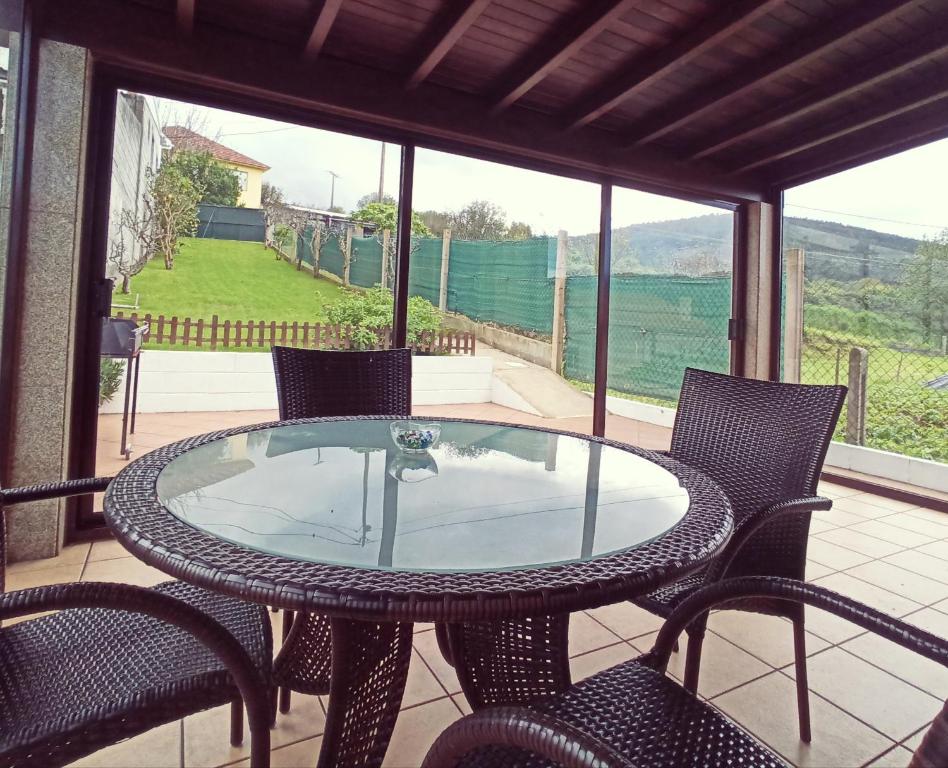 ア・コルーニャにあるCasa Mar de Ardoraのガラスのテーブルと椅子が備わるパティオ