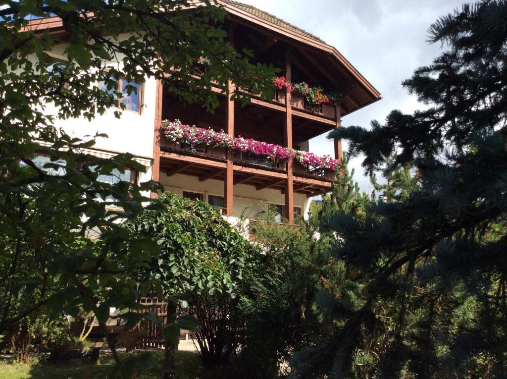 un edificio con un balcón con flores. en Residenze Sonnenschein Casa Bianca en Villabassa