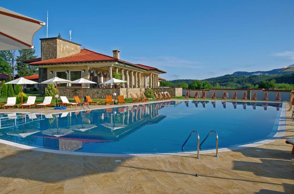 a large swimming pool in front of a house at Къща Наковски in Gabrovo
