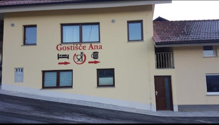 ein weißes Gebäude mit einem Schild an der Seite in der Unterkunft Hotel and Restaurant Ana in Hrib-Loški Potok