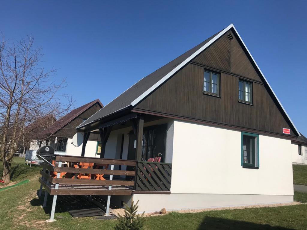 a large white and black barn with a porch at Happy Chalet in Černý Dŭl