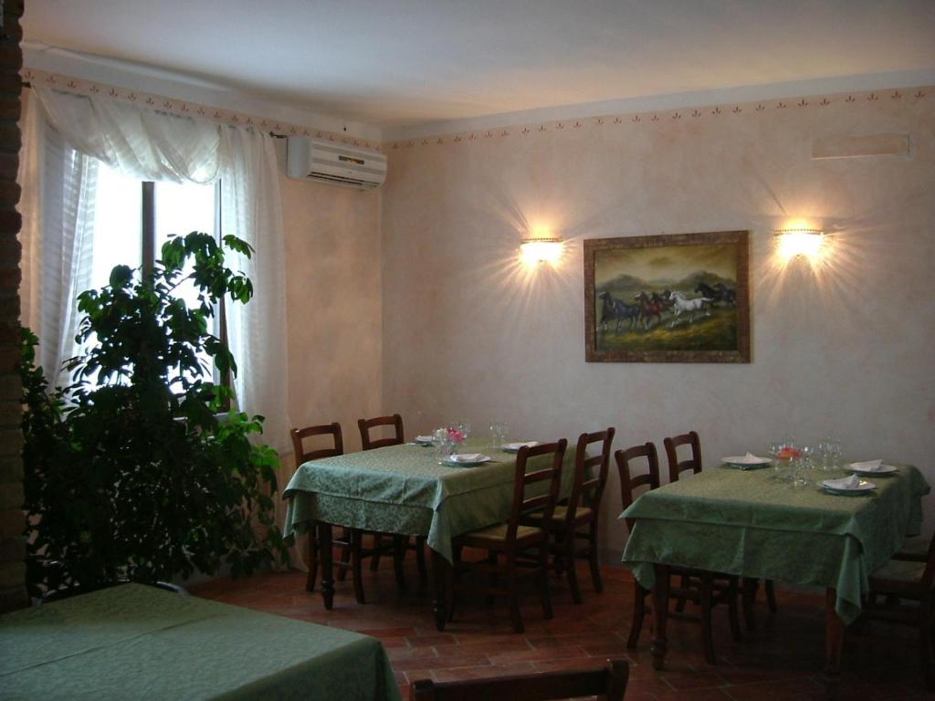 Agriturismo Cascina Gilli في Spino dʼAdda: غرفة طعام بها طاولات وكراسي و لوحة على الحائط