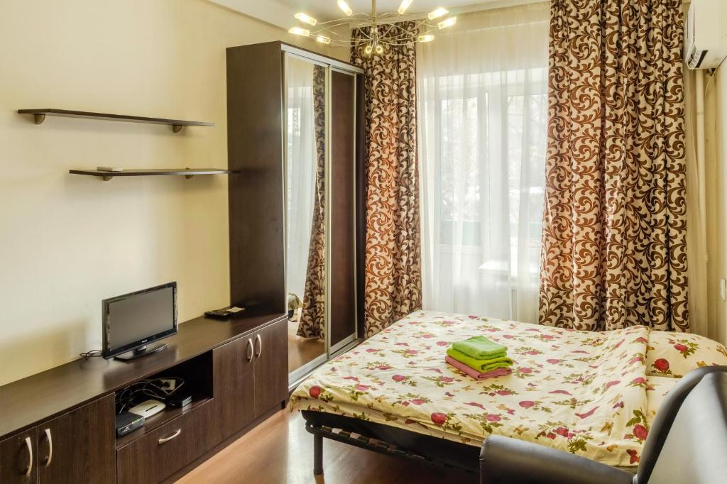 キーウにあるКвартира по улице Большая Васильковская, 114のベッド、テレビ、カーテンが備わる客室です。