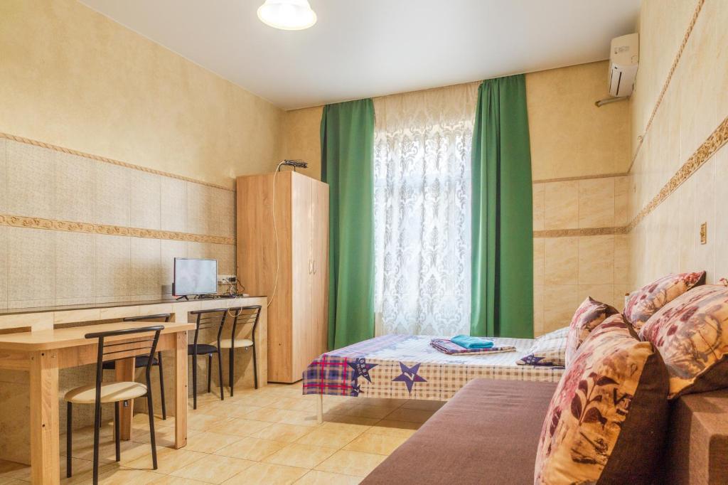 een kamer met een bed, een bureau en een tafel bij Квартира по улице Коновальца, 36-Э in Kiev