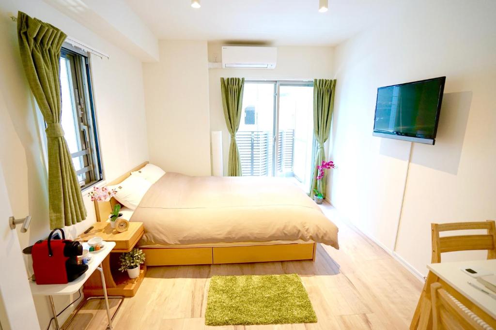 um pequeno quarto com uma cama e uma televisão em Jeffery Skytree Residence Tokyo em Tóquio