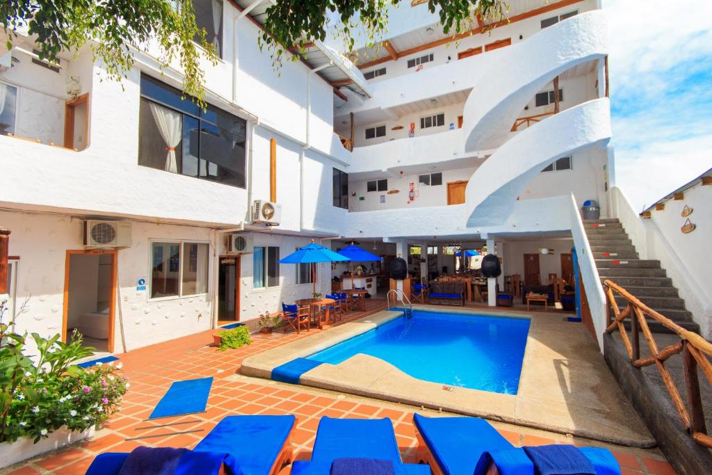 an apartment with a swimming pool in a building at Hotel La Casa de Judy in Puerto Ayora