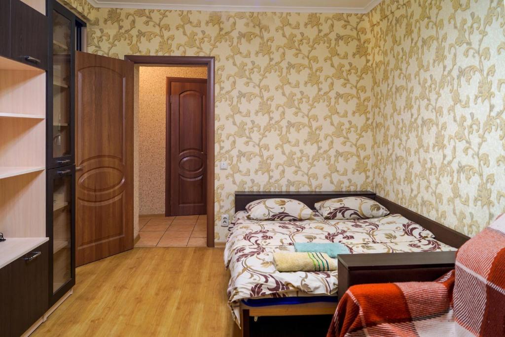 una camera con un letto in una stanza con carta da parati di Apartment in the city center Tsytadelnaya 7 a Kiev