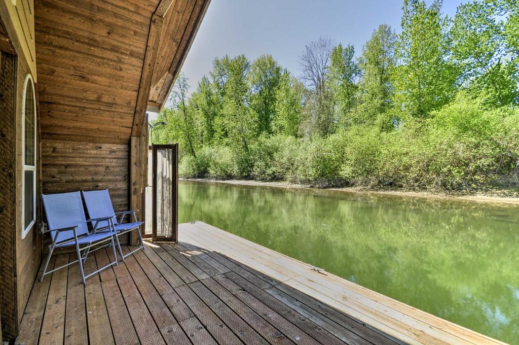 a deck with a chair and a view of a river at Floating Home on Columbia River with Provided Kayaks in Vancouver