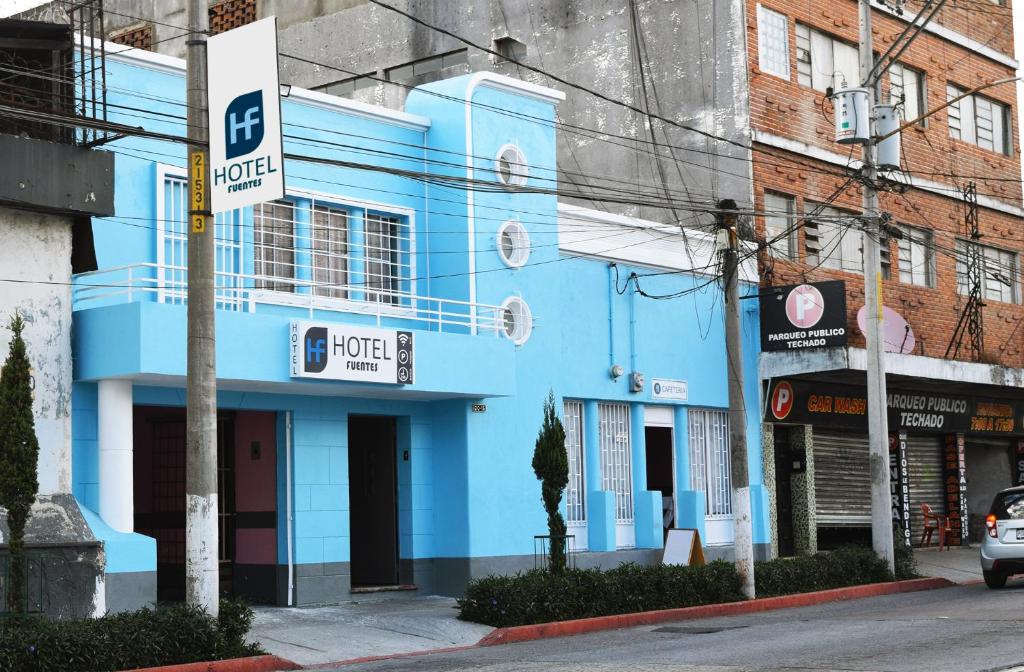 een blauw gebouw aan de straatkant bij Hotel Fuentes in Guatemala