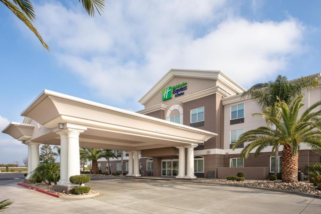 un hotel con un cartello sulla parte anteriore di un edificio di Holiday Inn Express & Suites Yosemite Park Area, an IHG Hotel a Chowchilla