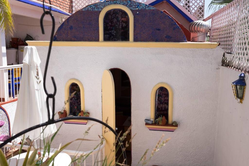 une maison de jouets avec trois fenêtres sur le côté d'une maison dans l'établissement Greek Cottage Playas de Tijuana, à Tijuana