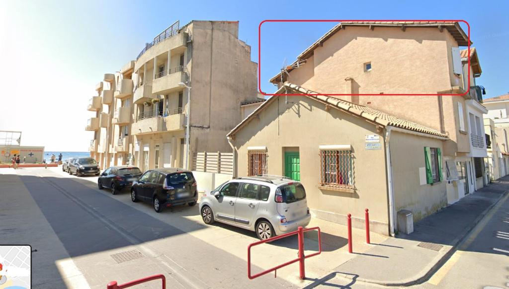 une rue avec des voitures garées à côté d'un bâtiment dans l'établissement Le Tribord - ambiance bateau avec balcon à 30 m de la plage, à Palavas-les-Flots