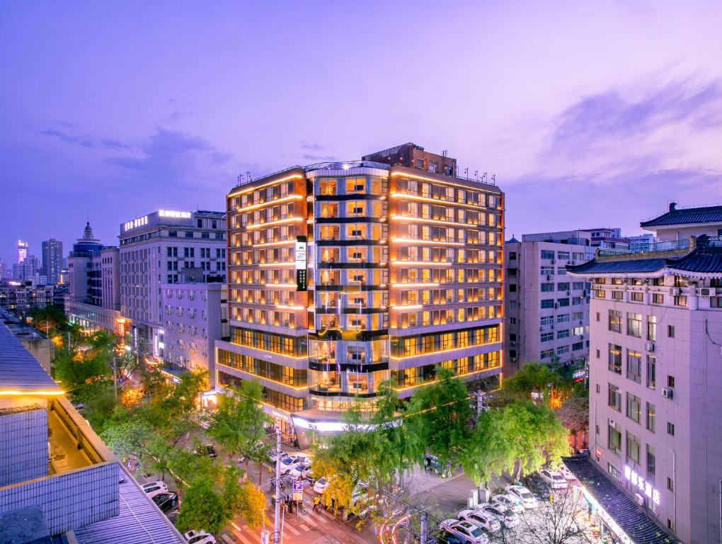 a tall building in a city at night at Jinmao Hotel Xi'an Downtown ( Bell & Drum Tower) in Xi'an