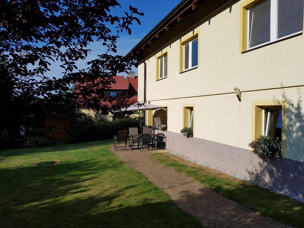 a house with chairs and a table in the yard at Ubytování U Šustrů in Horní Maršov