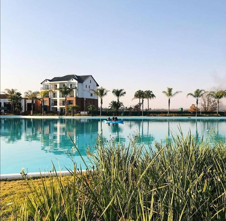 duży basen z domem i palmami w obiekcie Serenity@TheBlyde w mieście Pretoria