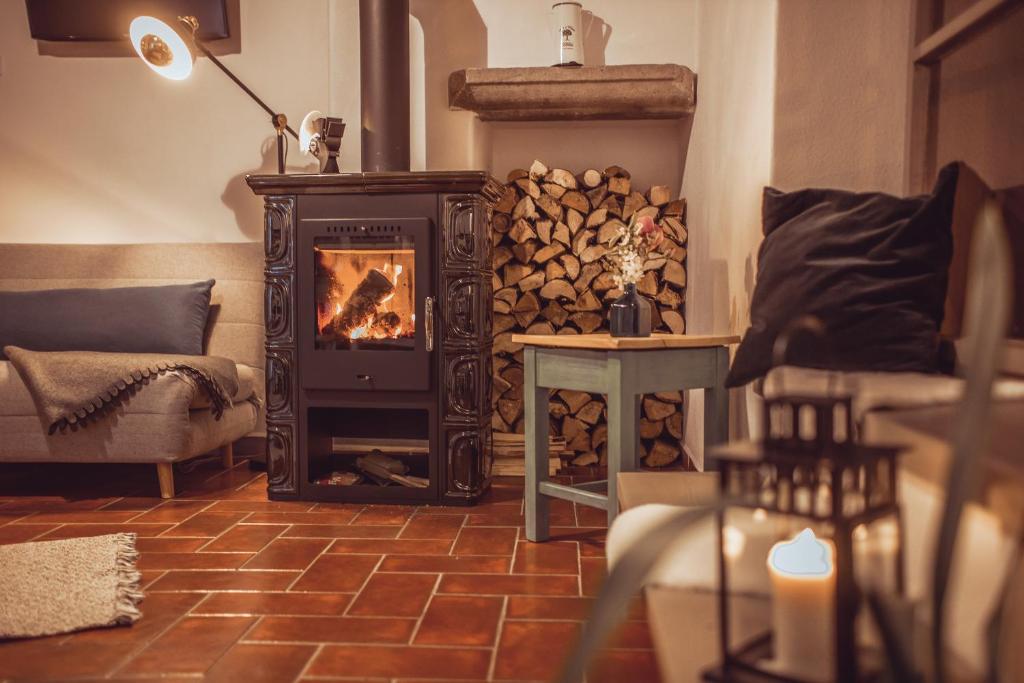 a living room with a fireplace and a pile of logs at Na Kozím plácku in Jindřichŭv Hradec