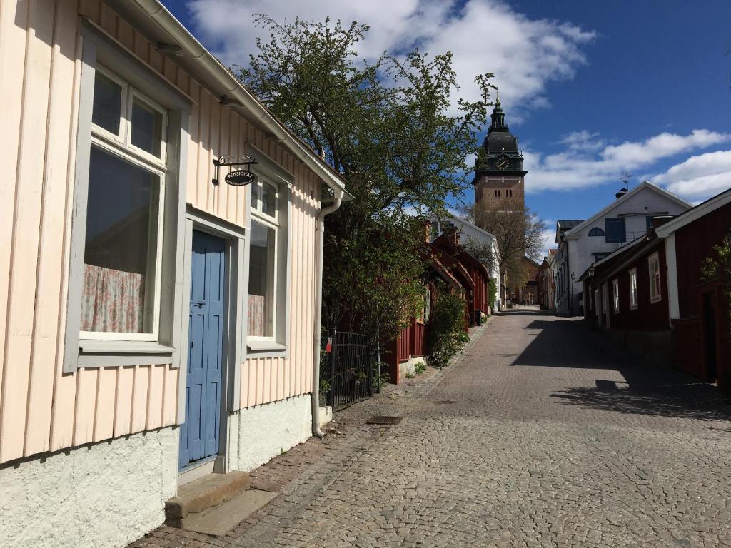 una calle vacía con un edificio y una torre del reloj en Pensionat Gyllenhjelmsgatan en Strängnäs