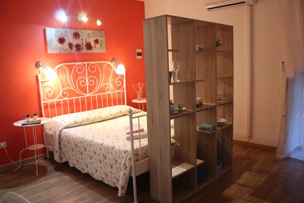 - une chambre dotée d'un lit avec un mur orange dans l'établissement La Piccola Casa di Angela, à Syracuse