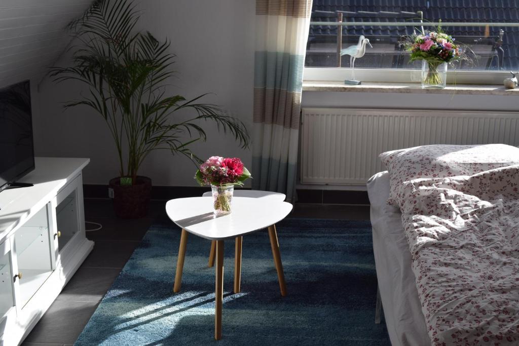 Ferienwohnung Knaack في بودلسدورف: غرفة معيشة بها سرير وطاولة عليها زهور