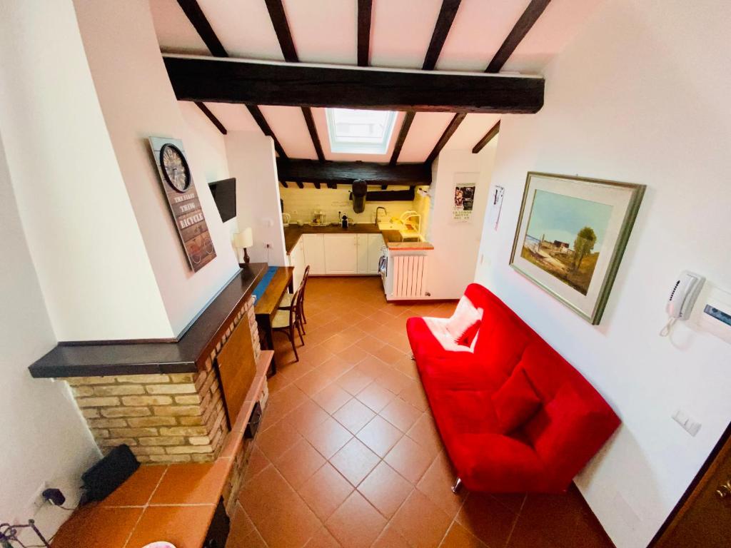 een woonkamer met een rode bank bij Dietro le volte in Ferrara