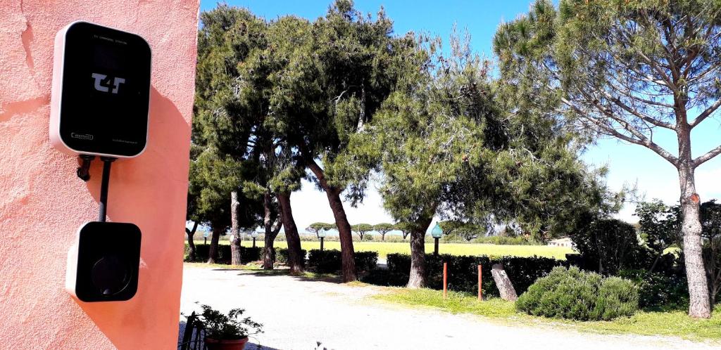 a phone on the side of a pink building with trees at Agriturismo Ristorante Monte Argentario in Monte Argentario