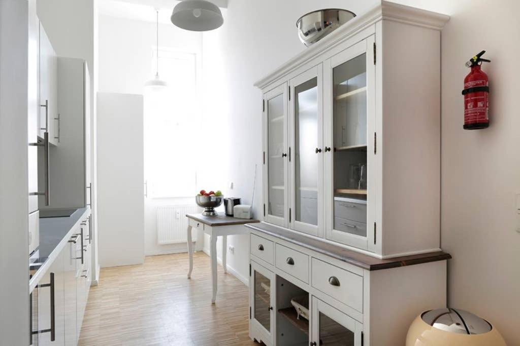 eine Küche mit weißen Schränken und einem Tisch in der Unterkunft SC 6 Cozy Family & Business Flair welcomes you - Rockchair Apartments in Berlin