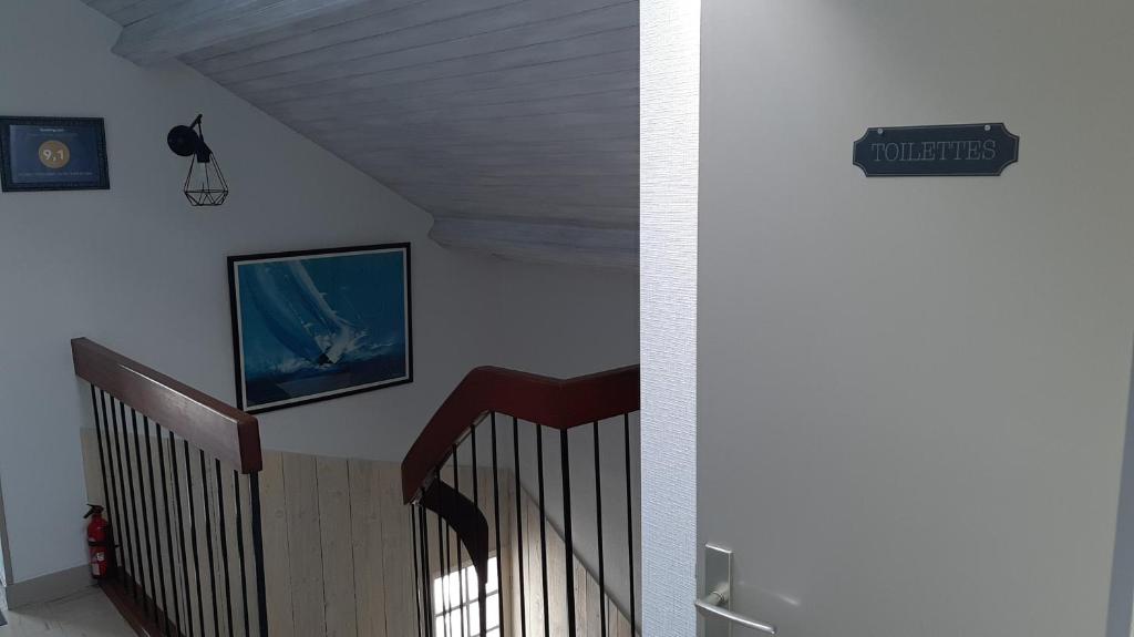 un pasillo con una escalera con un letrero en la pared en studio 2 personnes entre terre et mer, en Questembert