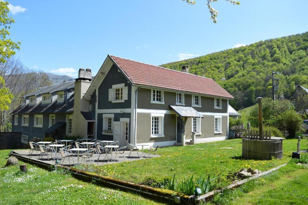 a house with tables and chairs in a yard at Maison d'hoursentut in Sainte-Marie-de-Campan