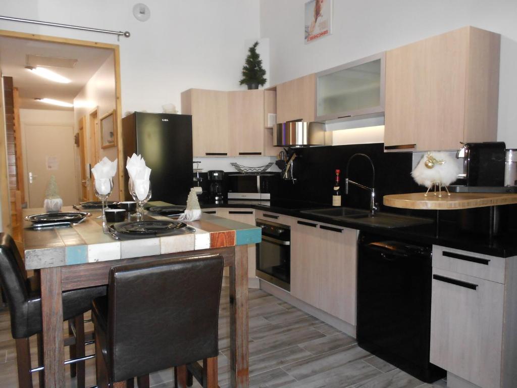 a kitchen with black appliances and a counter top at Charmant T2 en DUPLEX ARAVET113 in La Salle Les Alpes